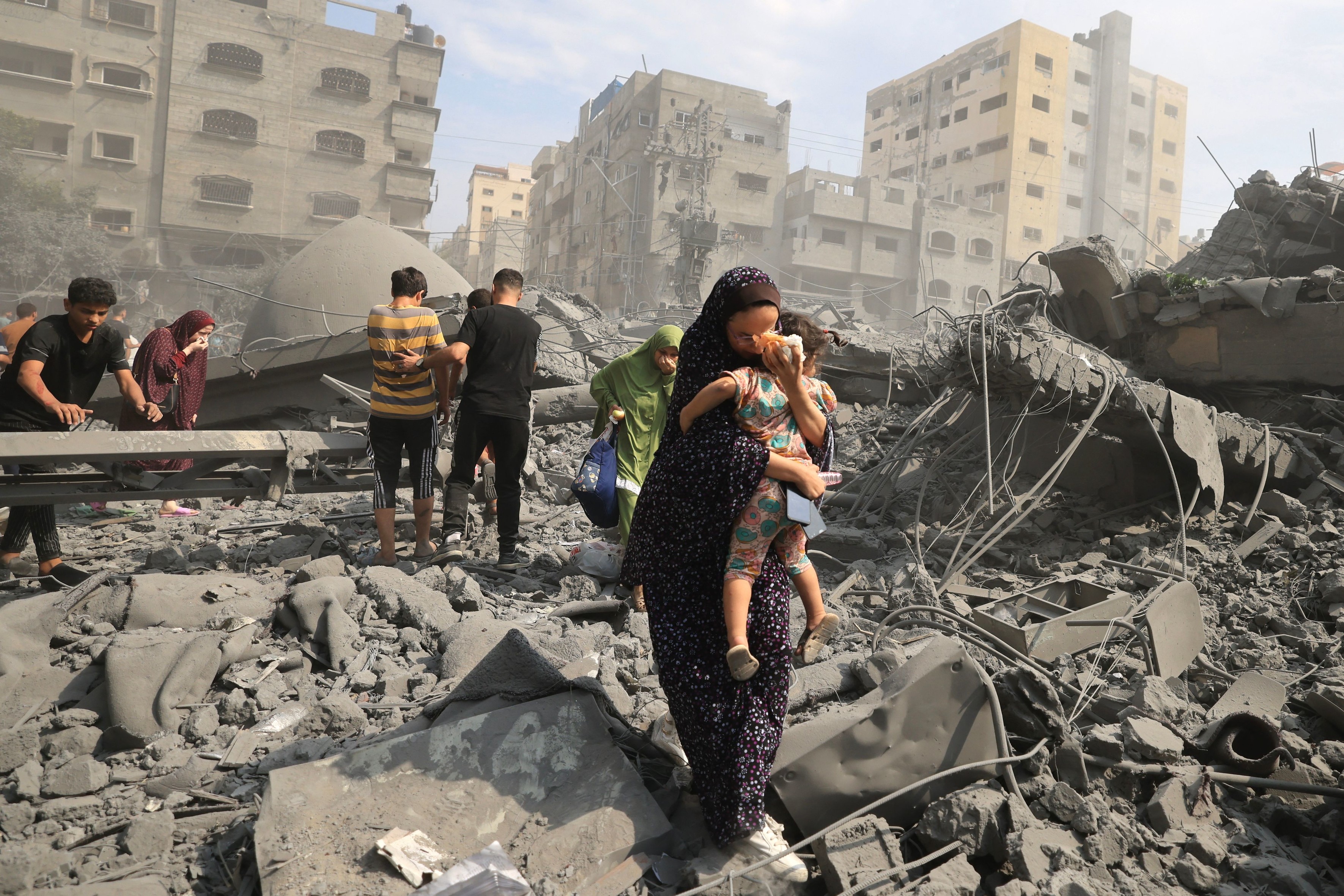 Palestinians evacuate the area following an Israeli airstrike on the Sousi mosque in Gaza City on October 9, 2023