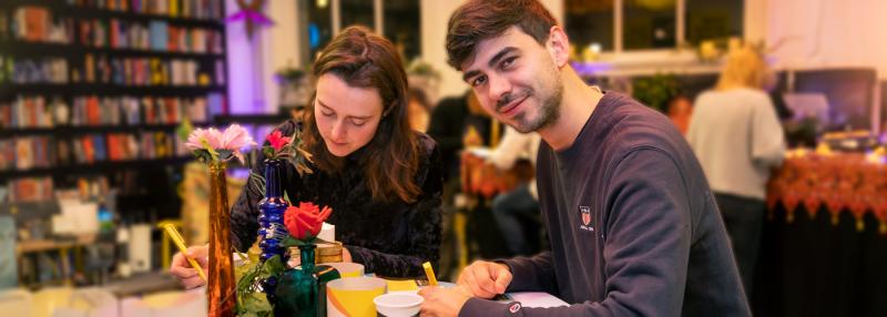 Zwei junge Personen, die Briefe schreiben, um beim Briefmarathon teilzunehmen.